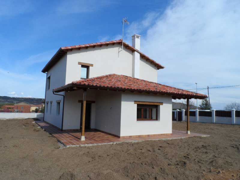 Chalet de obra nueva con dos plantas, pared blanca y porche