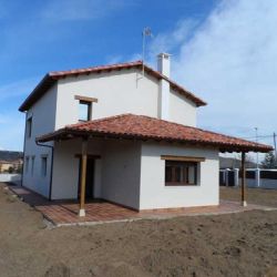 Chalet de obra nueva con dos plantas, pared blanca y porche