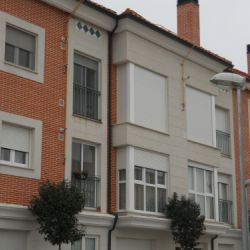 Obra nueva de vivienda de tres plantas con piedra blanca y ladrillo rojizo